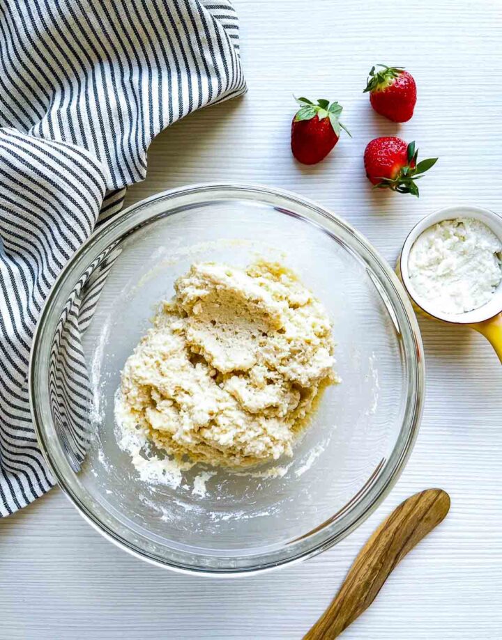 Thick ricotta cheese dough mixed in glass bowl