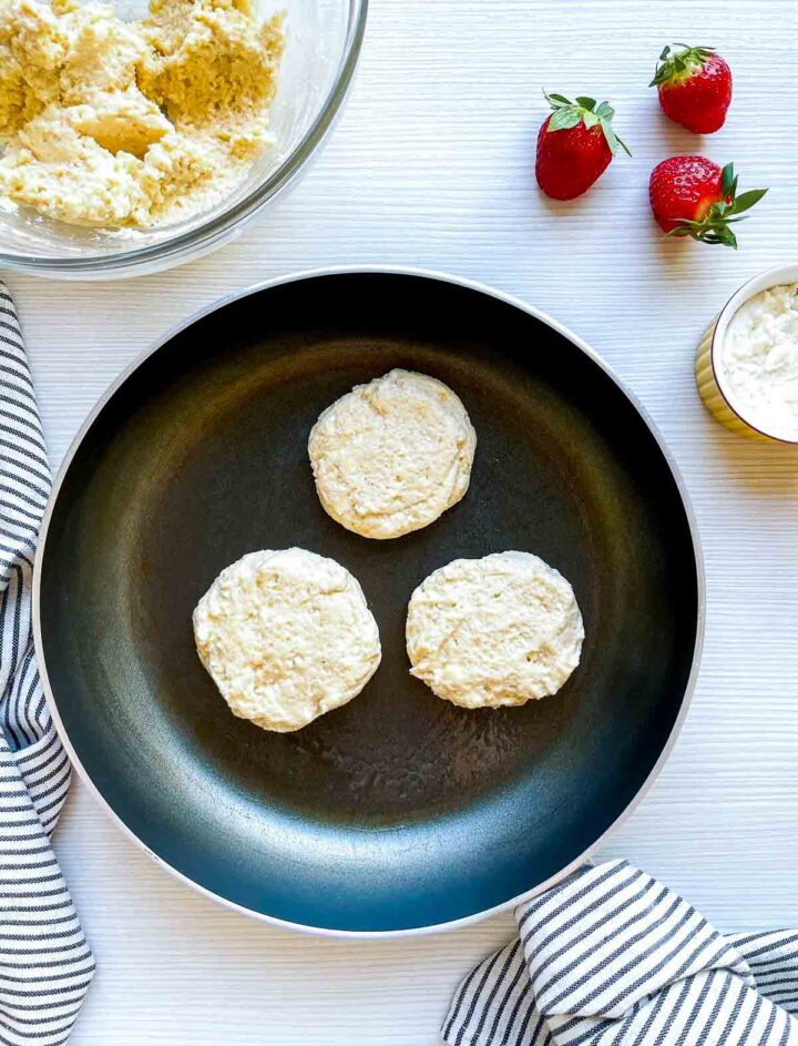 Ricotta cheese pancakes cooking in skillet.