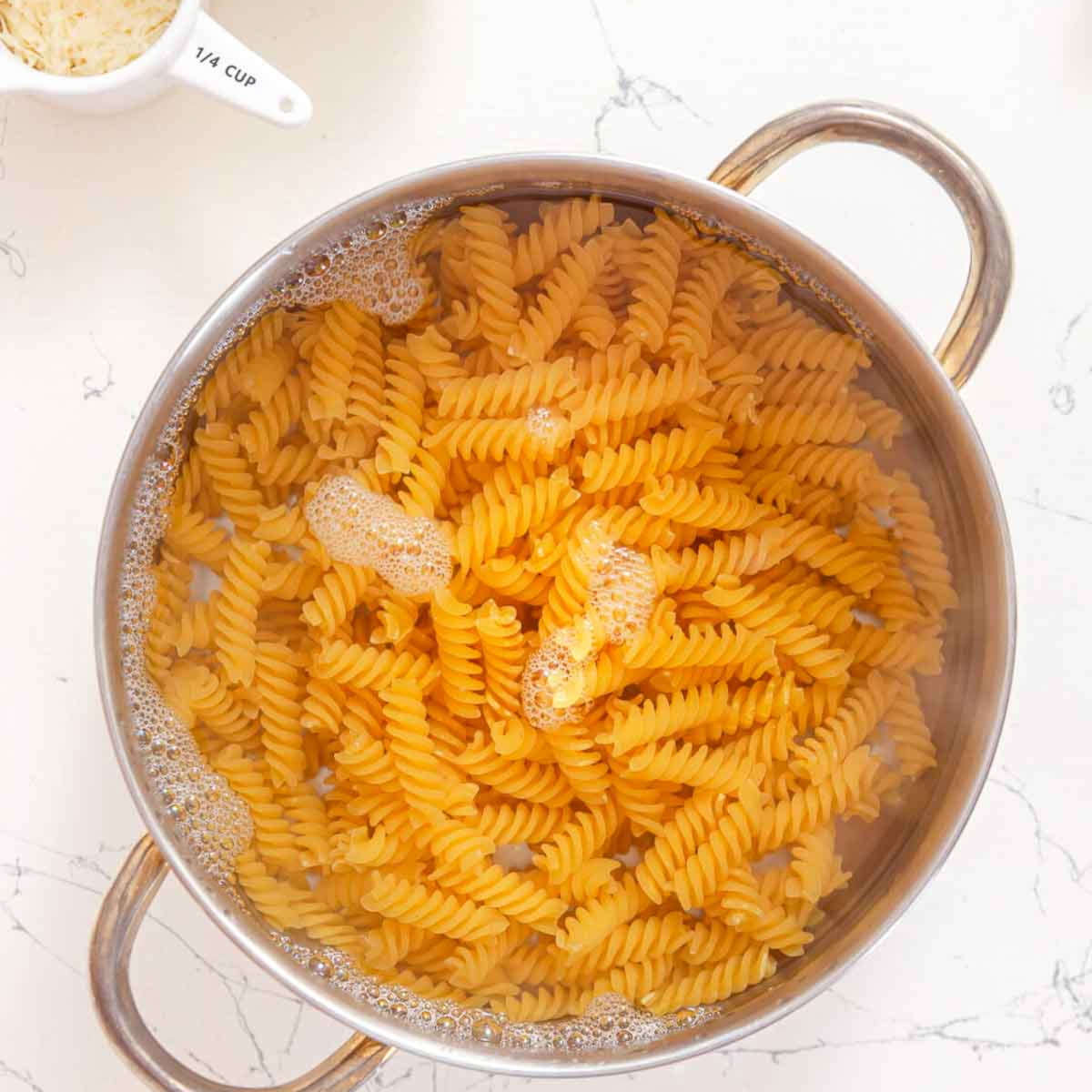 Rotini pasta boiling in a large pot of water.