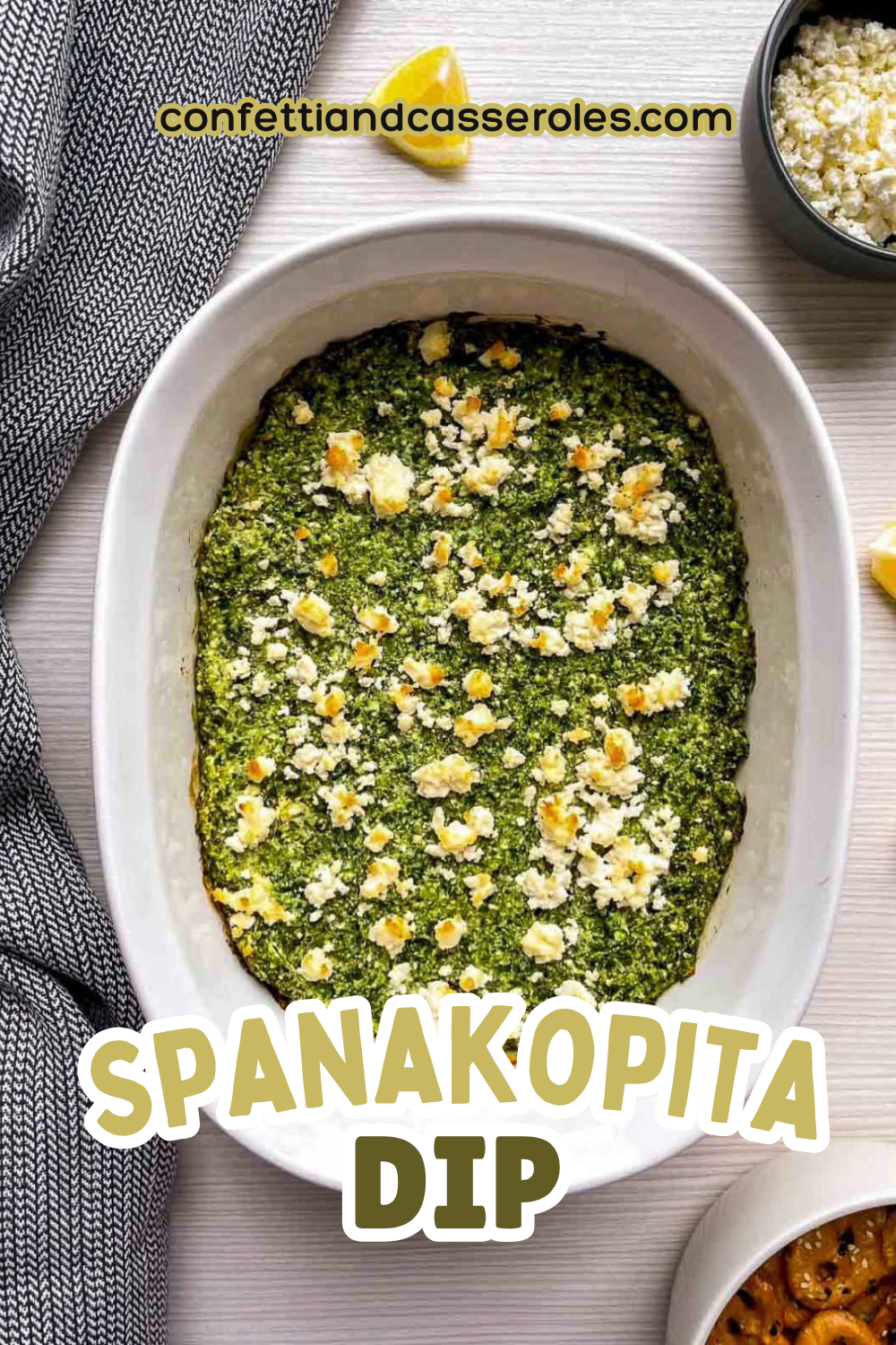 Pinterest pin showing a baked spanakopita dip in a white dish with golden feta on top, with the recipe title in text above it.
